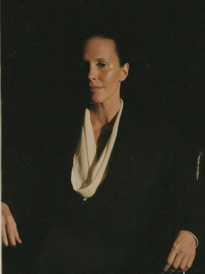 Studio portrait of an attorney in a black jacket and ivory blouse against a dark backdrop